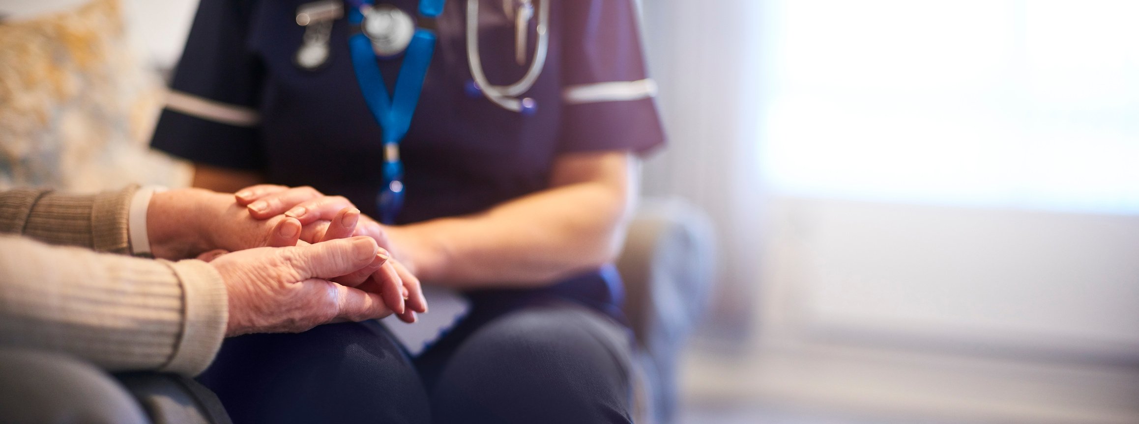 Nurse comforting patient at patient's home